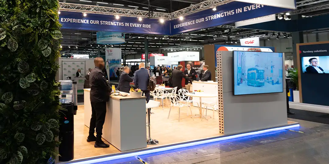 puff_eventservice Stand at Stockholmsmässan with visitors talking and a screen showing a presentation