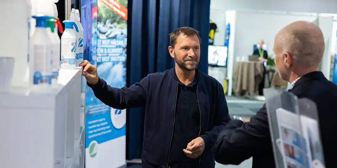 puff_varfor_stalla ut_ Exhibitor in conversation with a visitor at Stockholmsmässan – a meeting place for business and sustainable solutions in water and environment.