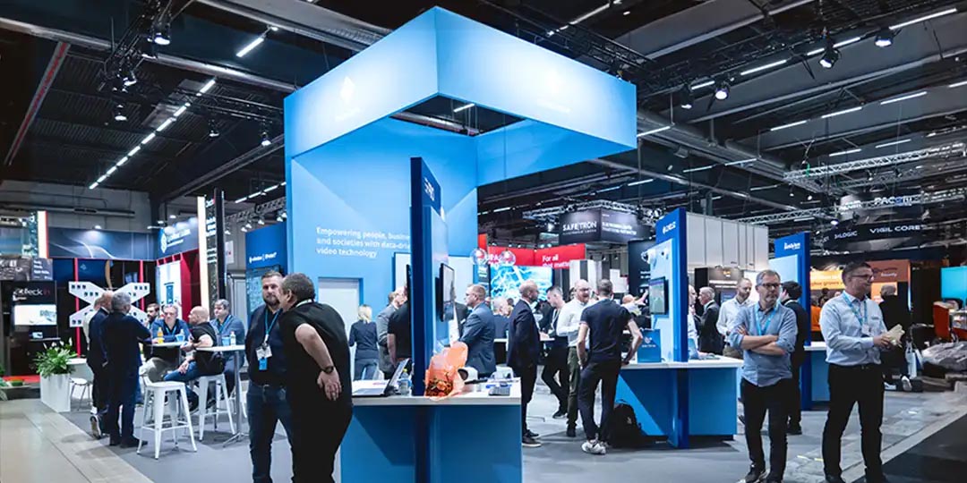 folk vid en monter-1080x540 Besökare och utställare på Stockholmsmässan i en modern mässmonter.